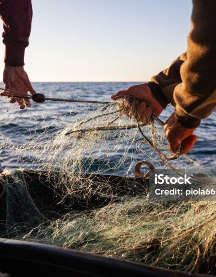 Fisherman at work with net on trawler fishing boat, typical small scale fisheries of the Mediterranean Sea